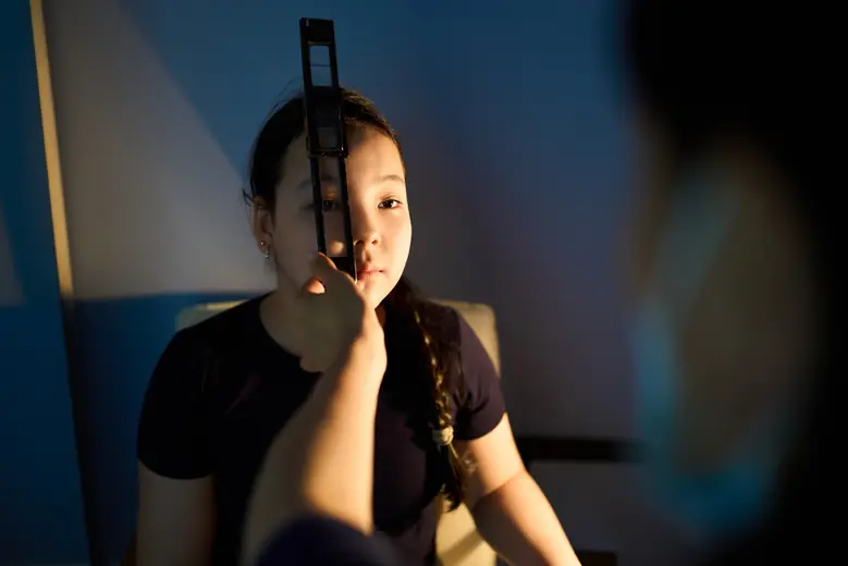 Девочка в тёмном кабинете BABY EYE CLINIC во время проверки