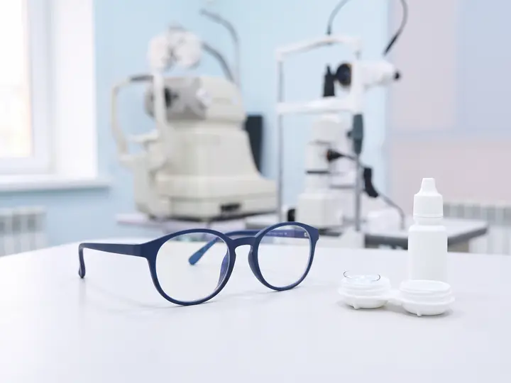 Детские очки и футляр для ночных линз на столе в кабинете BABY EYE CLINIC
