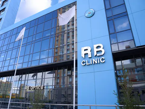 Здание RB CLINIC на ул. Орынбор, 12: синий фасад и пилон с буквами RB CLINIC