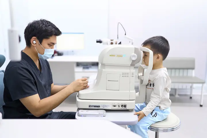 Врач BABY EYE CLINIC, детского филиала RB CLINIC, проверяет зрение мальчику