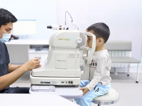 Врач BABY EYE CLINIC проверяет зрение мальчику