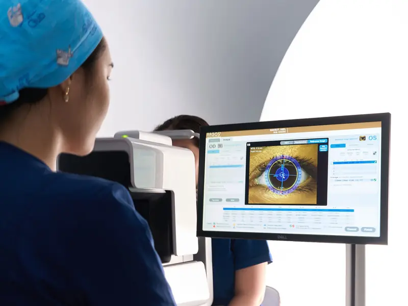 Медсестра за биометром Alcon ARGOS в кабинете диагностики RB CLINIC, на мониторе снимок глаза