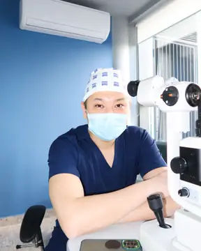Врач в маске за щелевой лампой: лазер сетчатки в RB CLINIC
