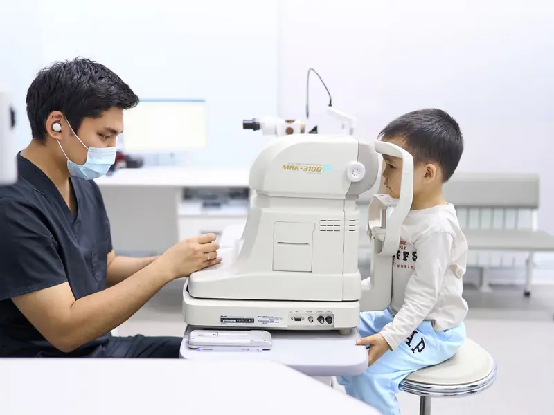В BABY EYE CLINIC мальчику проверяют зрение на приборе с окошком