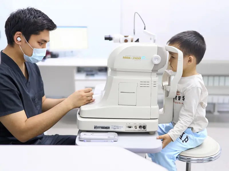 Врач BABY EYE CLINIC и мальчик у прибора: сначала знакомятся, потом смотрят