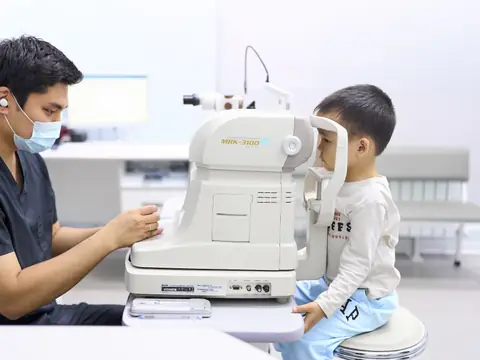 Врач BABY EYE CLINIC, детского филиала RB CLINIC, проверяет зрение мальчику